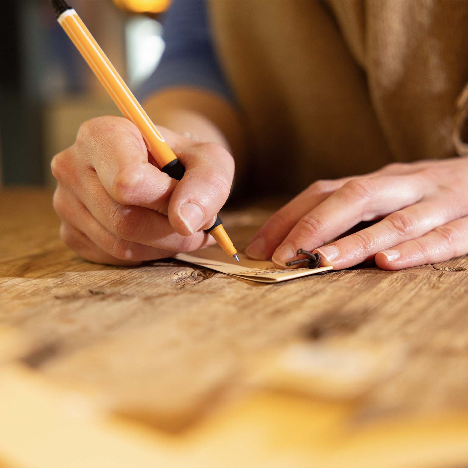 Frau schreibt Blog-Beitrag mit Stift in Tirol Geniessen Shop